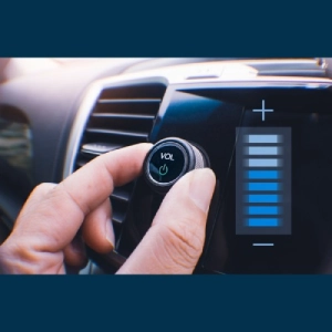 Driver adjusting audio volume on vehicle infotainment control system